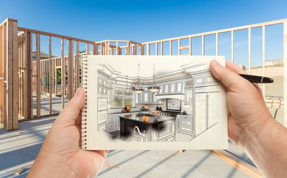 Male Hands Holding Pen and Pad of Paper with Custom Kitchen Illustration Inside Construction Framing.