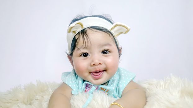 Asian Smiling baby girl crawling in bedroom