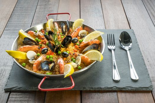 Paella with seafood vegetables and saffron served in the traditional pan