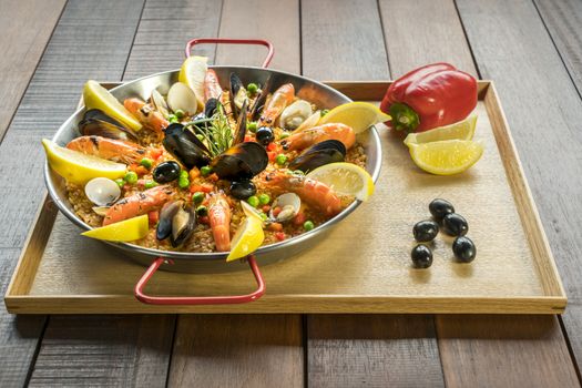 Paella with seafood vegetables and saffron served in the traditional pan