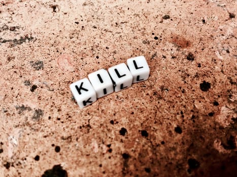White inscription. Small white square letters. Kill on the brown brick.