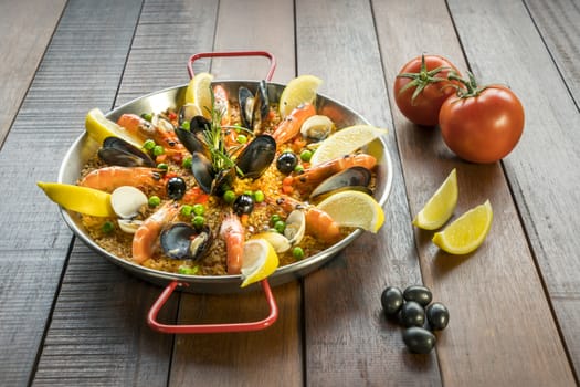 Paella with seafood vegetables and saffron served in the traditional pan