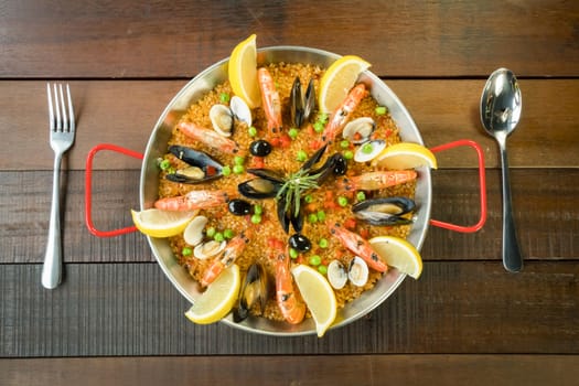 Paella with seafood vegetables and saffron served in the traditional pan.