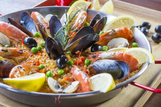 Paella with seafood vegetables and saffron served in the traditional pan