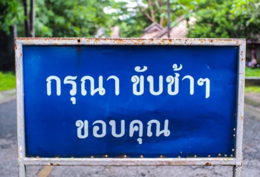Thai sign means "Please drive slowly, Thank"