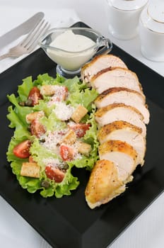 Sliced baked chicken breast with garnish  a la Caesar. 