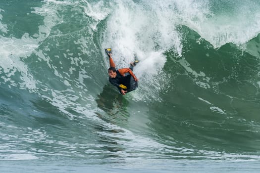 Bodyboarder in action on the ocean waves on a sunny day.