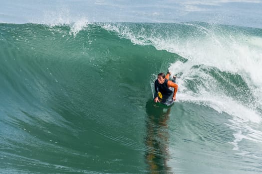 Bodyboarder in action on the ocean waves on a sunny day.