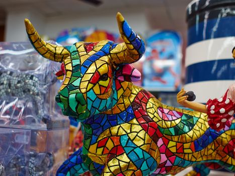 Miniature colorful statue of bull in Gaudi style - traditional classical souvenir in a market Spain