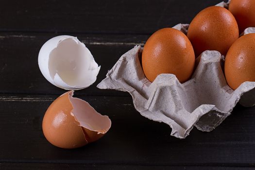 Cardboard egg box And eggshell shells on black wooden background. Eggs container