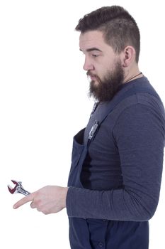 Bearded young man with a wrench in a working overall