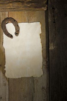 Rusty horseshoe and a sheet of paper on an antique door