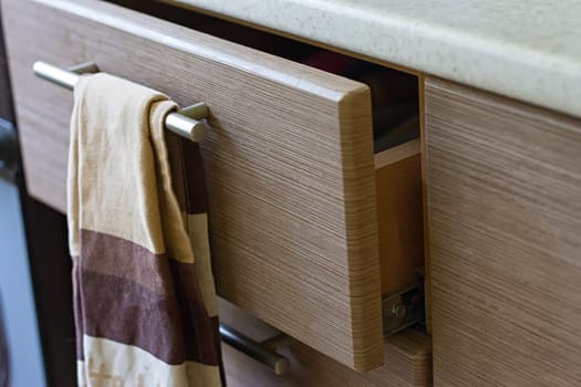 A pull-out kitchen box in the kitchen and a brown towel