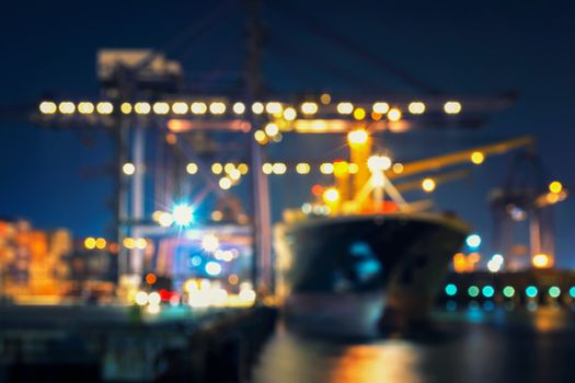 Blur bokeh of harbor with large ship and crane at night