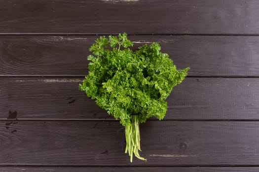 Fresh basil greens, parsley on a black background. Dark rustic style.