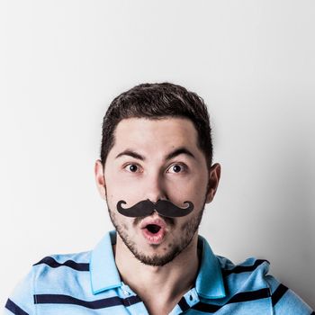 Portrait of man with retro style fake mustache and surprised facial expression
