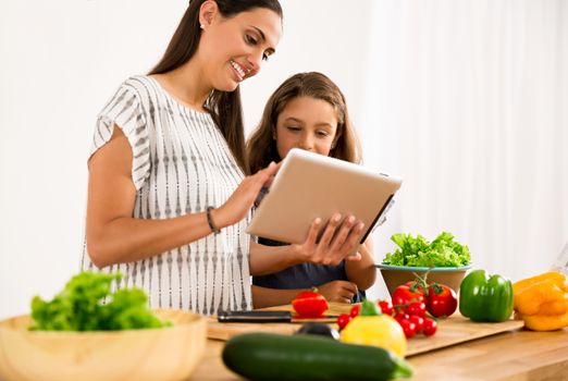 Shot of a mother and daughter having fun in the kitchen