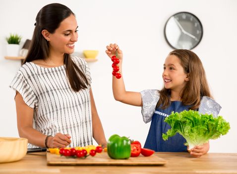 Shot of a mother and daughter having fun in the kitchen