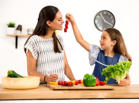 Shot of a mother and daughter having fun in the kitchen