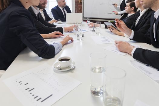 Business people at meeting table work with documents and financial data together