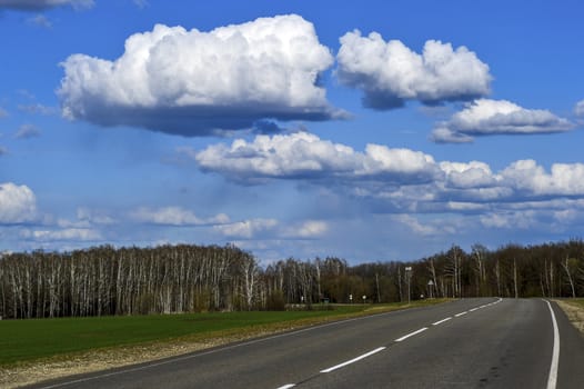 Road without cars with clouds.