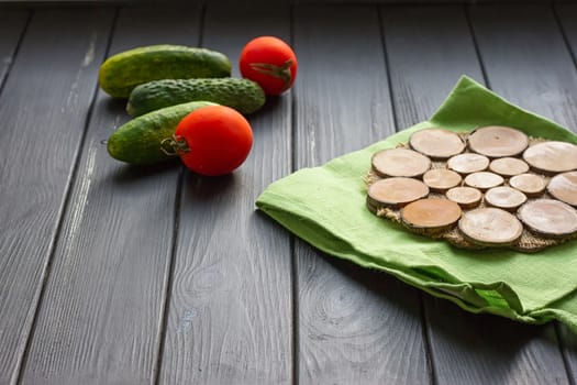 Tomatoes and cucumber on the black wood background