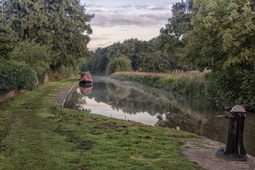 Early morning mist over the Trent and Mersey canal with reflections in the water