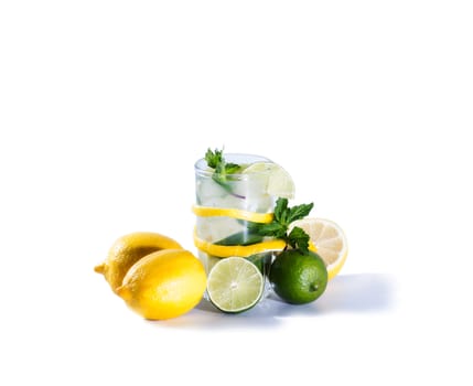 A glass of lemonade with lemon slices, lime, mint and ice