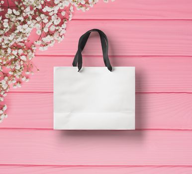 paper bag for shopping on a wooden pink background