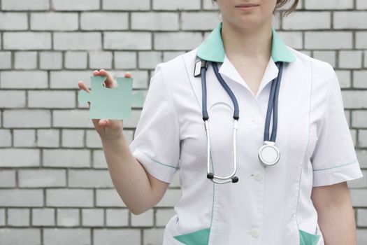 Medicine concept doctor. On a white brick wall background. system. Holds the puzzle one. Photo for your design