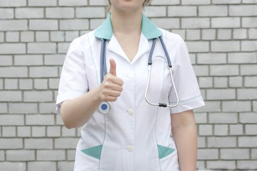 Medicine concept doctor. On a white brick wall background. thumbs up. luck. OK. Photo for your design