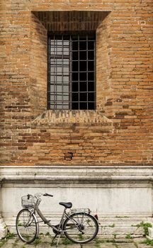 Old bicycle parked on a building wall in Ravenna, Italy