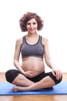 Young pregnant woman practicing fitness. Isolated on white background