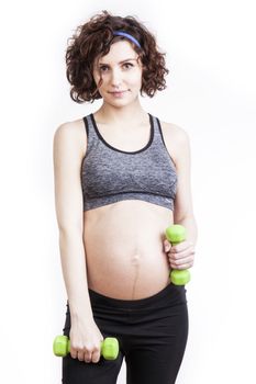 Young pregnant woman practicing fitness. Isolated on white background