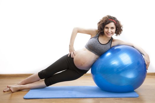 Young pregnant woman exercises with the ball.