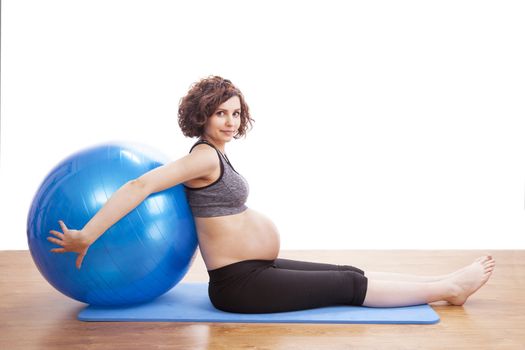 Young pregnant woman exercises with the ball.