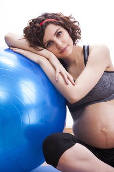 Young pregnant woman exercises with the ball.