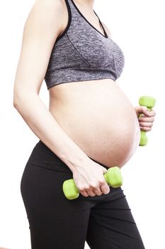 Young pregnant woman practicing fitness. Isolated on white background