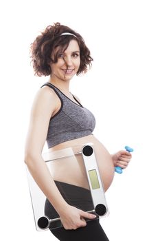 Young pregnant woman holding weight. Studio shot, isolated