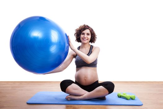 Young pregnant woman exercises with the ball.