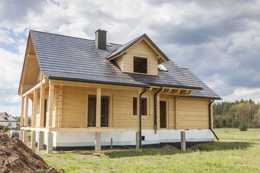 Wooden house with gray tiled roof - under construction.