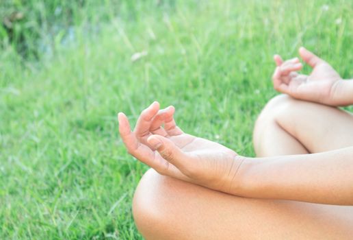 Closeup young woman yoga in the park at green grass, relax concept