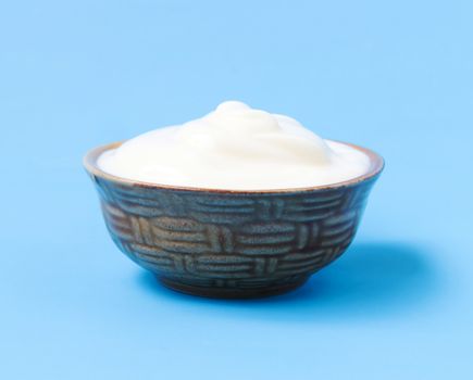 Greek yogurt in bowl with blue background