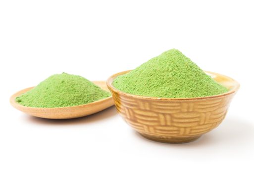 Green matcha tea powder in bowl white background
