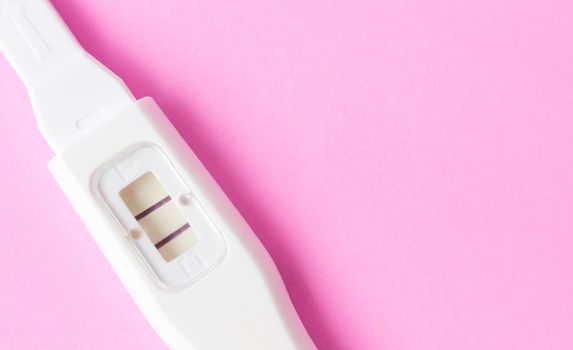 Pregnancy test on pink background, health care and medical concept