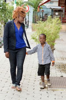 young woman walks with her little boy by talking to different places visited.