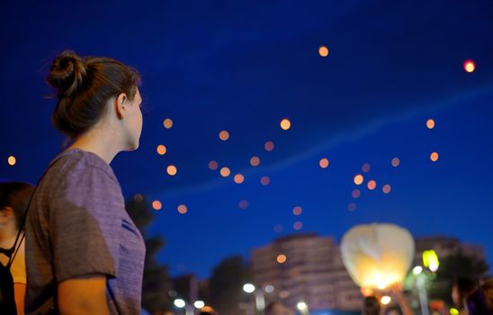 Teen Girl in summer night watching paper lantern