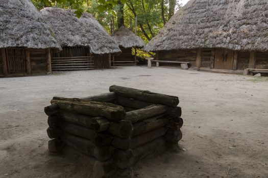 Well and wooden cottage in Biskupin museum - Poland.