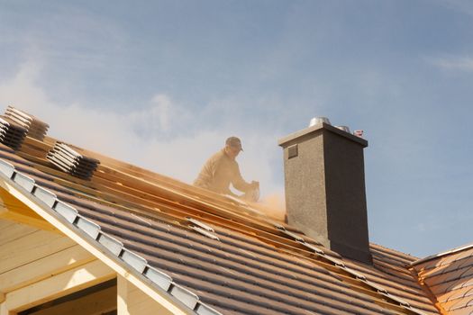 Roofer working on the top of the unfinished roof