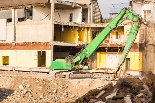 Excavator in front of a demolition site